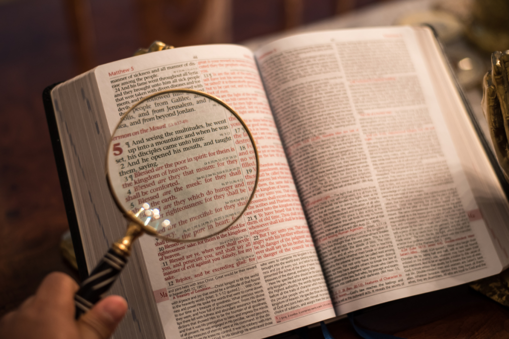 Open bible with a magnified glass to display christians directing the Bible to determine God's intent for marijuana. 