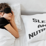 Woman sleeping in a bed next to a pillow that reads, "sleep and nutrition".